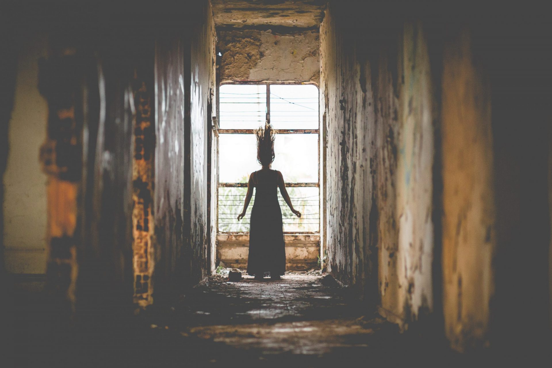 Eine Frau steht in einem Korridor und ihr stehen die Haare zu Berge