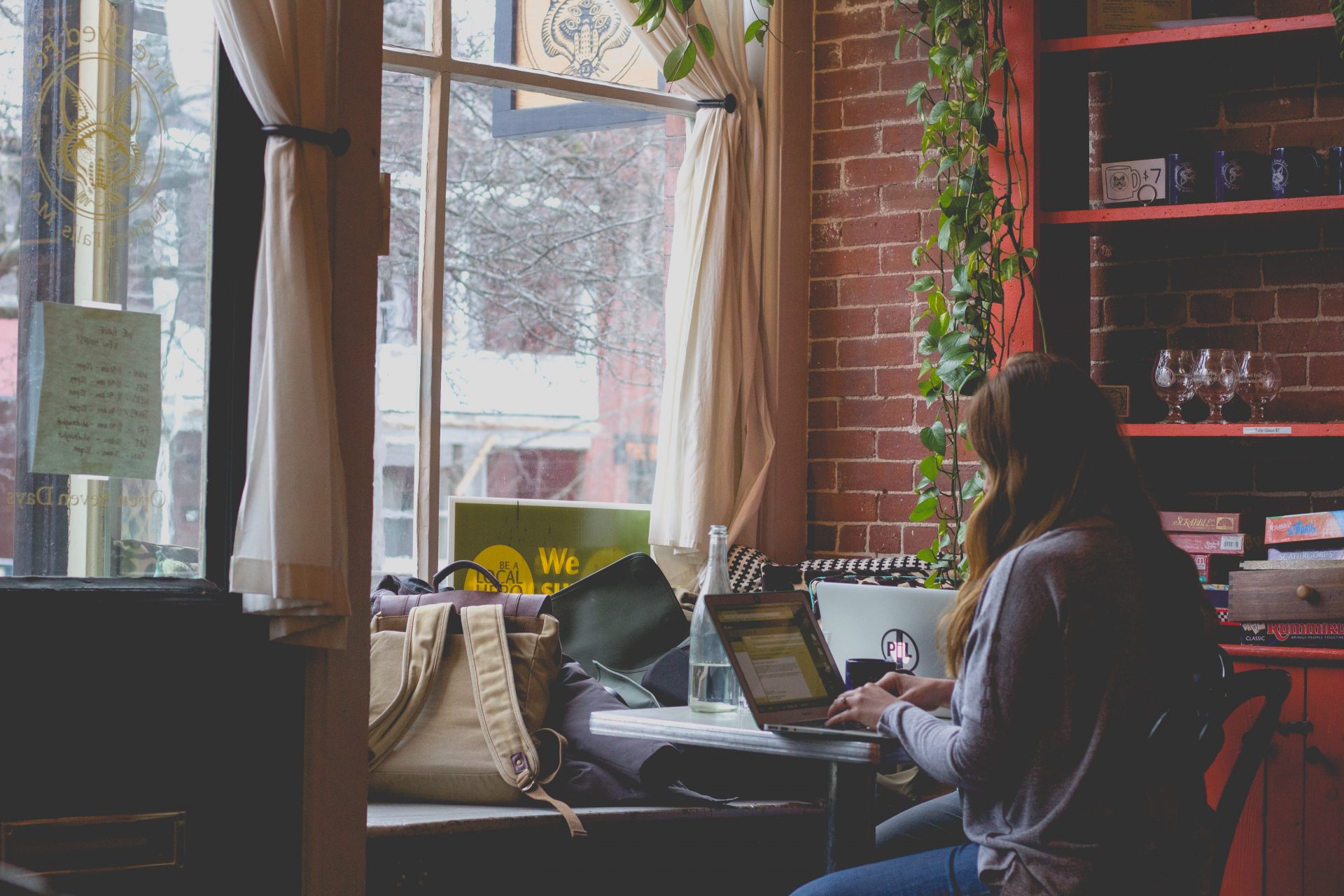 Eine Frau sitzt an ihrem Laptop in einem Café